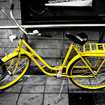 Yellow bike on a black and white street